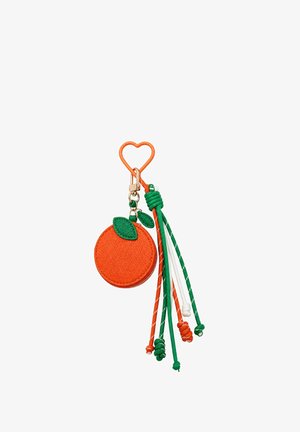 Oranje ronde pouch met groene bladeren bevestigd aan een oranje hartvormige sleutelhangertje en meerkleurige geknoopte koorden die aan de zijkant hangen.