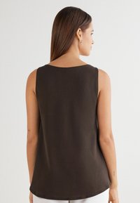 Braunes ärmelloses Oberteil mit rundem Ausschnitt und lockerem Sitz. Glatte Textur und gerade Saumabschluss am unteren Rand.