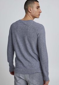 Fitted, long-sleeve sweater in a speckled dark blue knit fabric. Ribbed collar and cuffs, with a smooth texture and minimalist design.
