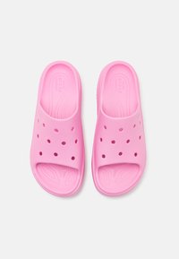 Sandales à glissière roses en matériau flexible, avec des trous de ventilation, un bout arrondi et une semelle intérieure texturée pour le confort.