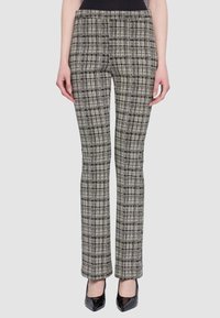 Pantaloni a quadri bianchi e neri con una vestibilità aderente, caratterizzati da un design a gamba dritta e una texture liscia. Indossati con tacchi alti.