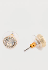 Arany színű fülbevalók, középen egy tiszta drágakővel, amelyet kisebb, tiszta rhinestone-ok vesznek körül, texturált háttérrel és tűs kivitelezéssel.