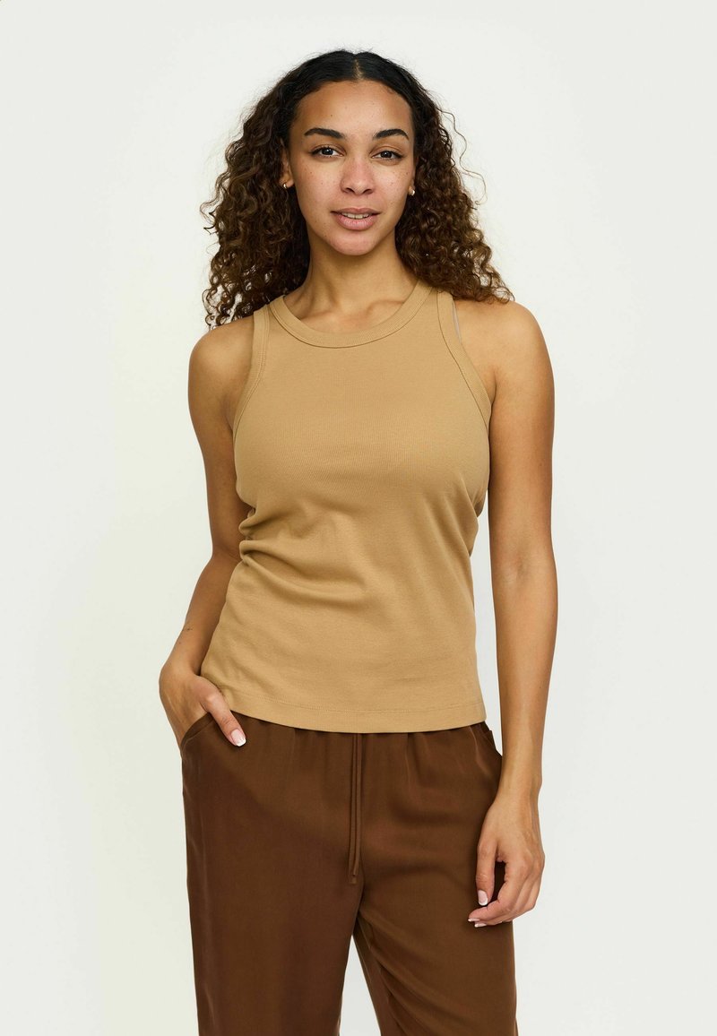 Krammi ilma varrukatank top beežist ribikangast, ümarate kaelustega ja keha külge liibuv disain, koos laiale pruunide pükstega.