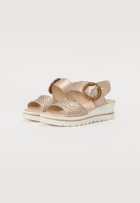 Kile sandaler i metallisk beige med vevet tekstur, justerbar stropp og trespenne som detalj. Tjukk hvit såle med mønster.