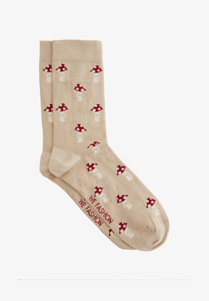Bež nogavice z ponavljajočim se vzorcem rdečih in belih pikčastih gob, ki prikazujejo besedilo "WE FASHION" blizu predela prstov.