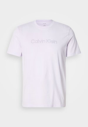 Camiseta blanca de manga corta y cuello redondo con el logo en relieve de "Calvin Klein" en el pecho, mostrada sobre un fondo liso.