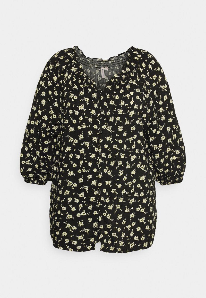 Blouse noire boutonnée avec petit motif floral crème, manches trois-quarts bouffantes et col à volants.