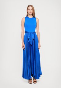 Maxikleid in leuchtendem Blau, mit einem eng anliegenden, ärmellosen Oberteil und einem gefalteten Rock, der in der Taille mit einem Bindegürtel geschnürt ist. Glatte Stofftextur.