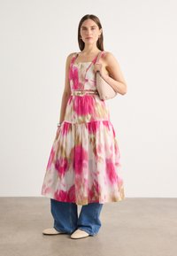 Robe à imprimé floral en rose et blanc, dotée d'un décolleté carré, d'une taille ceinturée et d'une jupe fluide ; associée à des chaussures en denim et crème.