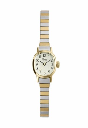 Reloj de pulsera pequeño Timex con caja ovalada en tono dorado, esfera blanca, números negros y correa de eslabones metálicos alternados en plata y oro.