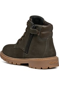 Stivale alla caviglia in pelle verde scuro con zip laterale, lacci e suola in gomma beige con motivo a rilievo. Logo del marchio sul tallone.