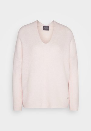 Svetlo roza pulover s V-izrezom, izdelan iz mehkega blaga, s sproščenim krojem in rebrasto teksturo. Opazna podrobnost logotipa na robu.