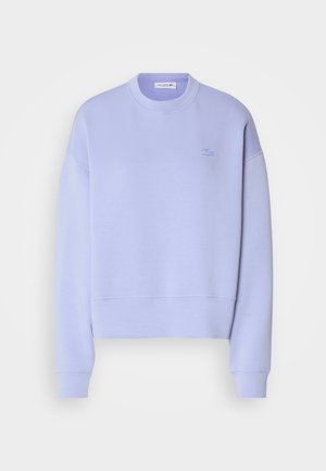 Light purple sweatshirt with a crew neck, ribbed cuffs, and hem; features a small embroidered logo on the left chest. Soft fabric texture.