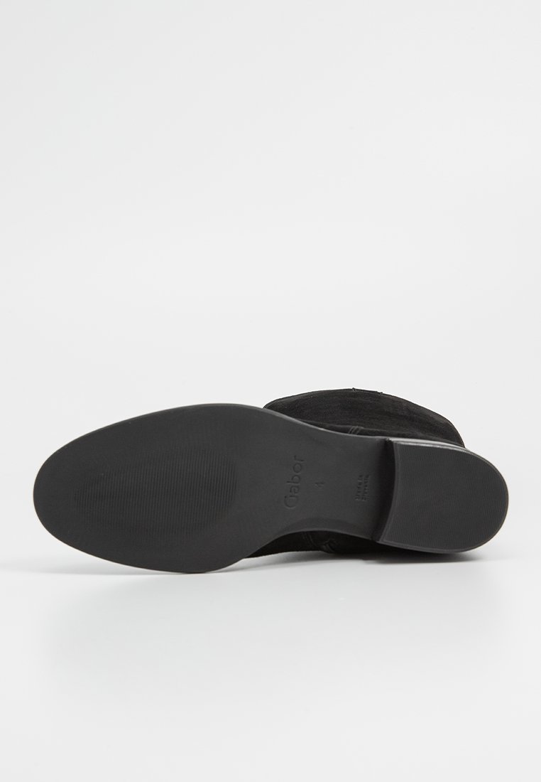 Schwarze Wildleder-Stiefelette mit glatter Sohle, abgerundeter Zehenpartie und niedrigem Absatz. Das Gabor-Branding ist auf der Unterseite sichtbar.