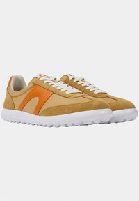 Zapatillas de gamuza marrón y tela beige con acentos naranjas, cordones blancos y una suela de goma blanca gruesa con agarres redondeados.