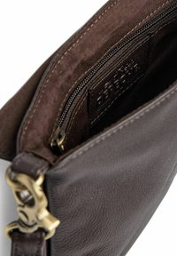 Tmavohnedá kožená kabelka so zapínaním na zips vo vnútri, vykazujúca hladkú textúru a viditeľné zlaté kovové detaily. Má vnútornú štítok.