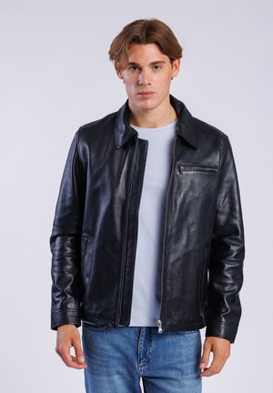 Giacca in pelle nera con una texture liscia, colletto a revers e tasca sul petto con zip. Presenta una chiusura frontale con zip e tasche laterali.