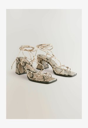 Sandale cu toc bloc și șireturi, cu imprimeu de python în nuanțe de bej și verde. Bot pătrat și curele împletite care adaugă textură și detaliu.