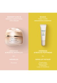 Två hudvårdsprodukter sida vid sida: en guldfärgad burk med Shiseido Benefiance ögonkräm på en rosa bakgrund och ett vitt rör med Waso Yuzu-C essence på gul bakgrund.