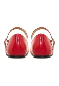 Rote Lacklederschuhe mit runder Zehenpartie, Knöchelriemen und silberfarbener Hardware, die eine glatte, glänzende Oberfläche und eine flache schwarze Sohle haben.
