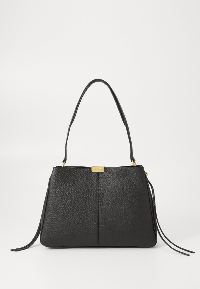Sac à main en cuir noir texturé avec une seule bandoulière, une fermeture rectangulaire dorée et des pampilles décoratives en cuir sur fond blanc.