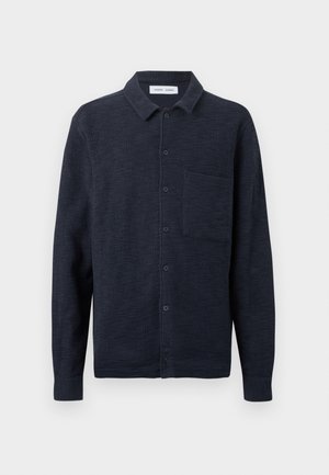 Dark navy button-up long-sleeve shirt with a textured fabric and a single chest pocket, displayed against a plain white background.