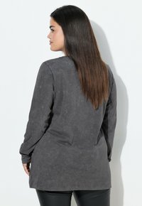 Top de manga larga en gris oscuro, hecho de tejido texturizado, con un corte holgado y un dobladillo curvado. Apto para uso casual.