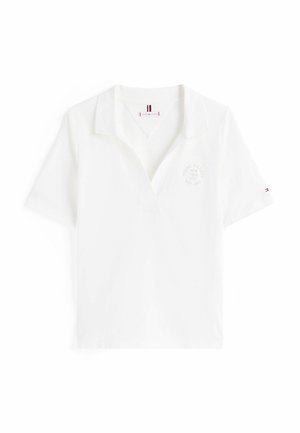 Polo shirt blanc à manches courtes, col, et un logo imprimé subtil sur la poitrine. Matériau en coton avec une texture lisse.