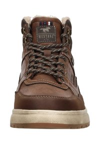 Bruine leren high-top sneaker met patroonveters, gesponsorde Mustang logo patch en beige gestructureerde zool, vooraanzicht.