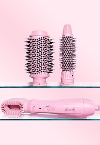 Set de coiffure rose comprenant deux brosses rondes avec des poils et un outil de coiffure avec une prise texturée et des boutons de contrôle.