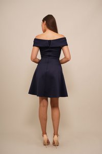 Abito camicione blu navy con spalle scoperte, dotato di corsetto aderente e gonna svasata. Tessuto morbido con chiusura a zip sul retro. Scarpe alte color cuoio.