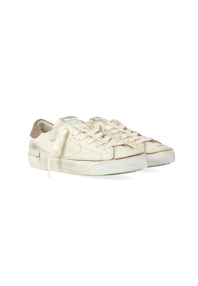 Sneakers in pelle bianca sporca con dettagli beige sul tallone, lacci annodati in modo sciolto e suole in gomma bianca testurizzata.