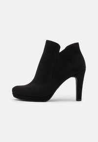Bottes noires en suède à la cheville avec un bout pointu, un talon aiguille haut et un design à découpe asymétrique sur les côtés. Texture lisse.