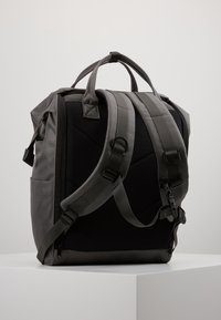 Šedý a černý batoh s polstrovanými popruhy, texturovaným materiálem, dvojitými horními úchyty a více zipovými oddíly pro úložný prostor.