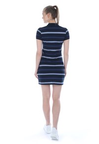 Kurzkleid in Navy- und Graustripes mit tailliertem Schnitt und Kragen, kombiniert mit weißen Sneakers. Glattes Material mit einem lässigen Look.