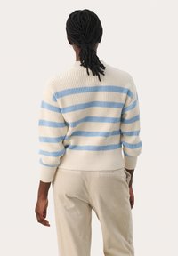 Pull en maille avec des rayures horizontales bleu et crème, doté d'un col rond, de poignets côtelés et d'une coupe décontractée. Détail de tissu texturé.