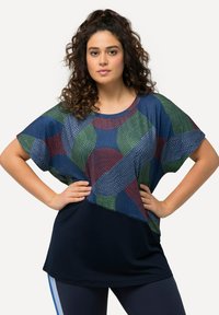 Blusa de manga corta con un patrón geométrico en azul, verde y rojo sobre una tela ligera con una sección inferior en azul oscuro.