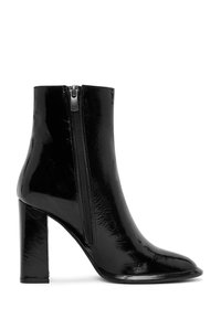 Bottine en cuir verni noir avec un bout carré, un talon bloc haut et une fermeture éclair sur le côté. Texture lisse avec une finition brillante.