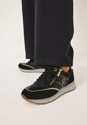 Svarta sneakers med en blandning av läder och mocka, med en zip-detalj, grå accenter och en rundad sula.
