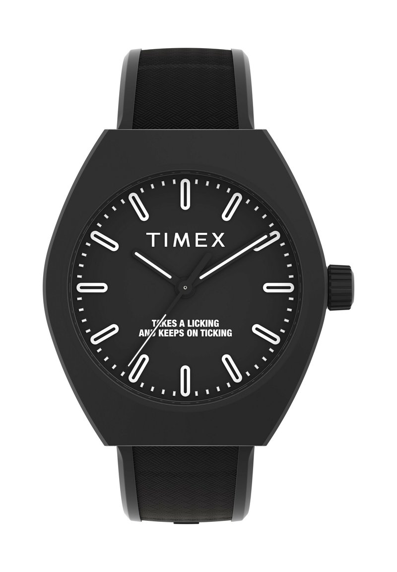 Melna Timex pulksteņa dizains ar izteiksmīgu daudzstūru korpusu, baltu stundu marķējumu un struktūrētu gumijas siksniņu. Uz pulksteņa ciparnīcas redzams drosmīgs sauklis.