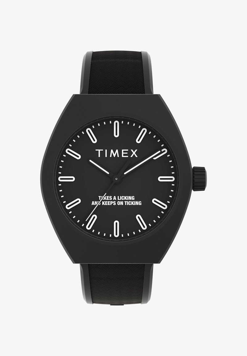 Melna Timex pulksteņa dizains ar izteiksmīgu daudzstūru korpusu, baltu stundu marķējumu un struktūrētu gumijas siksniņu. Uz pulksteņa ciparnīcas redzams drosmīgs sauklis.