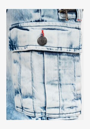 Denim jackszak met een lichtblauwe en witte wassing, voorzien van een metalen knop, rode stiksels en dubbel gestikte naden.