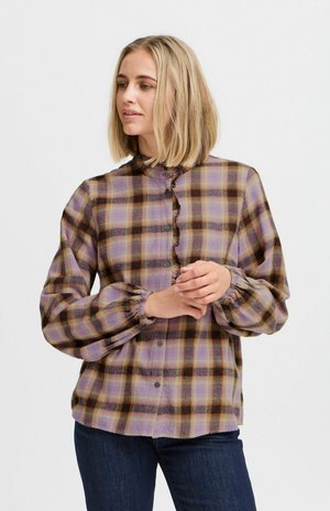 Chemise à carreaux à manches longues dans des tons de violet, jaune et noir. Présente un col à volants, une fermeture à boutons sur le devant et des manches froncées. Tissu texturé.