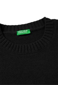 Černý pletený svetr s vroubkovaným kulatým výstřihem. Obsahuje zelenou etiketu s nápisem "UNITED COLORS OF BENETTON." Texturovaný vzor po celém povrchu.