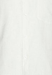 Camisa de lino blanca con un cuello clásico, seis botones y un bolsillo en el pecho. Tejido texturizado con una calidad natural y transpirable.