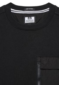 Sweat-shirt noir à col ras du cou avec étiquette "WEEKEND OFFENDER", texte "ADMIT NOTHING" sur le col, et une poche zippée sur la poitrine.
