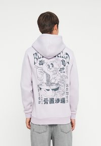 Light purple hoodie featuring a large graphic on the back of a skeleton eating ramen with chopsticks, complemented by bold text.