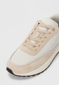 Bež i krem tene sa gornjim delom od antilopa i sintetičkih materijala, s okruglim vrhom, ravnim vezicama i teksturiranim gumiranim đonom.