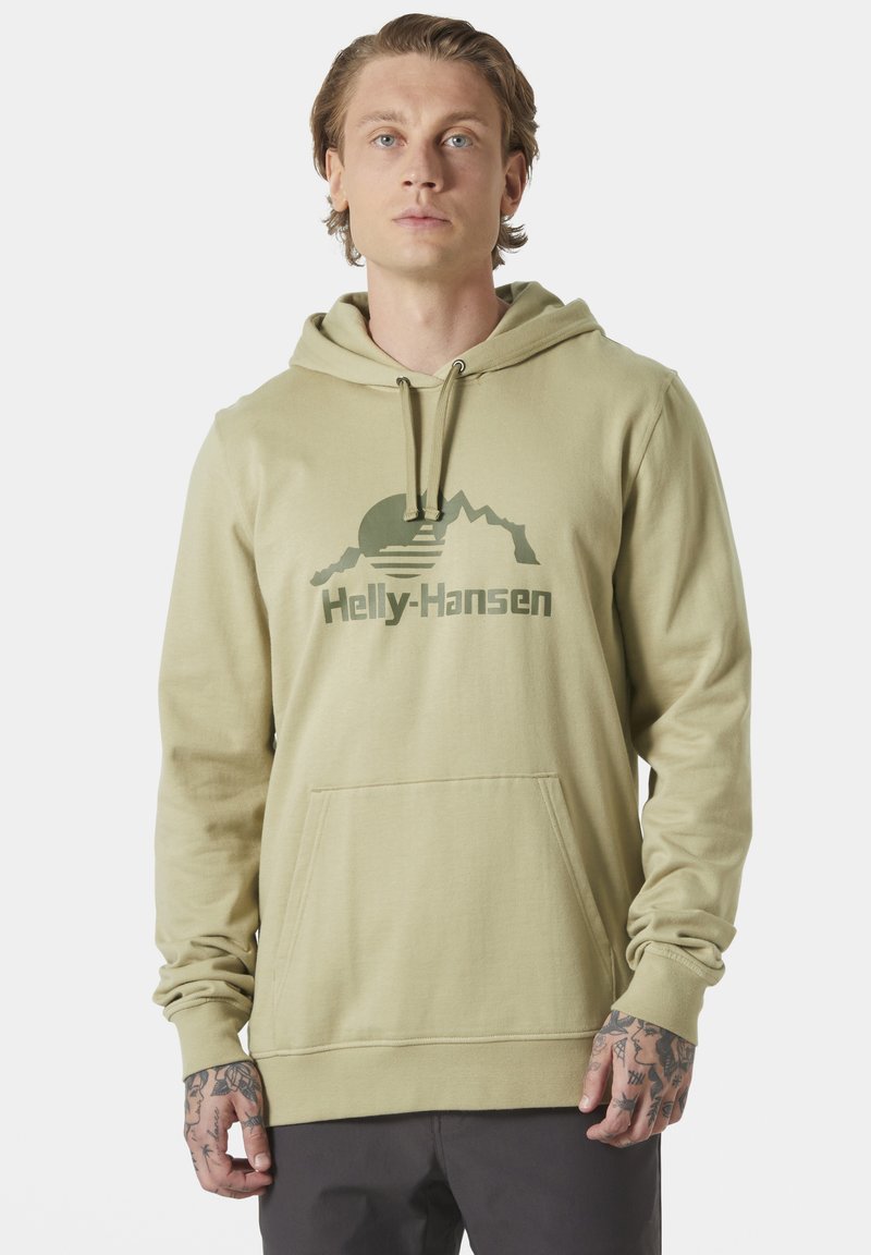 Sudadera color caqui con un bolsillo frontal, capucha con cordón y un estampado gráfico verde de montañas y el nombre de la marca "Helly-Hansen". Textura de tela suave.