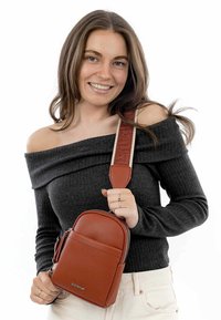 Brun struktureret læder crossbody taske med lynlåslukning, der har en mønstret justerbar rem og en frontlomme som detalje.